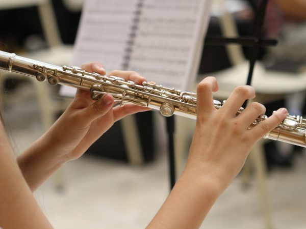 A Las Vegas student playing the flute in an orchestra.