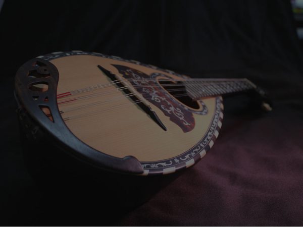 A brown mandolin horizontally laying on the studio floor.